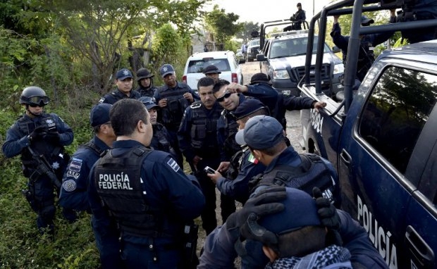 La police fédérale se déploie sur le lieu où un charnier a été découvert près d'Iguala, le 10 octobre 2014 La police fédérale se déploie sur le lieu où un charnier a été découvert près d'Iguala, le 10 octobre 2014