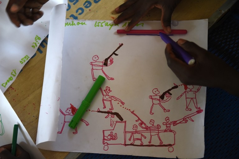 Un jeune réfugié nigérian dessine une scène d'attaque par Boko Haram pendant une séance de thérapie organisée par l'Unicef dans un camp près de Baga Sola, au Tchad, le 6 avril 2015 Un jeune réfugié nigérian dessine une scène d'attaque par Boko Haram pendant une séance de thérapie organisée par l'Unicef dans un camp près de Baga Sola, au Tchad, le 6 avril 2015
