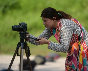 In this photograph taken on August 30, 2016,  Shazia Bhatti, a Pakistani 38-year old journalist shoots video footage during an assignment in Islamabad. / AFP PHOTO / AAMIR QURESHI
