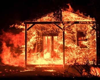  Flames overtake a structure as nearby homes burn in the Napa wine region in California on October 9, 2017, as multiple wind-driven fires continue to whip through the region.  / 
