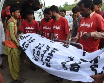 Des volontaires transportent vers la morgue le corps de Shafqat Hussain, exécuté le 4 août 2015 à Karachi (AFP / Asif Hassan)